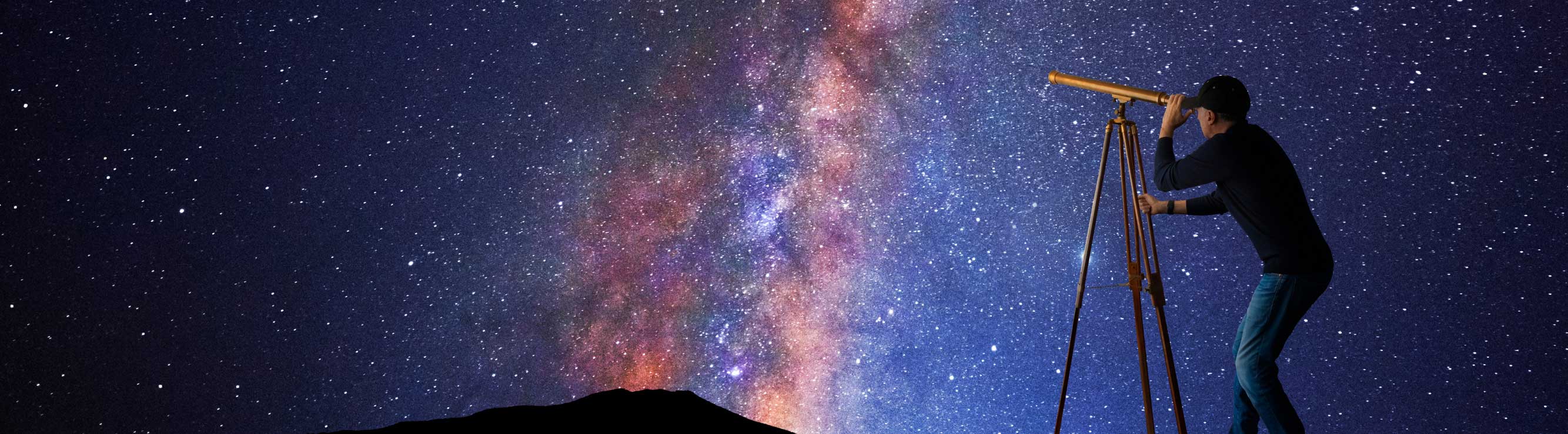 man looking at starts through a telescope