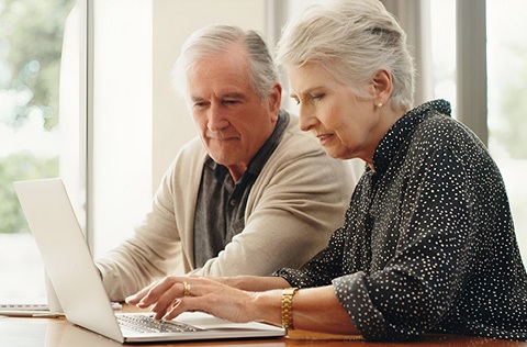 two seniors looking at a computer