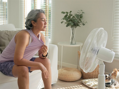 lady getting cool in front of a fan