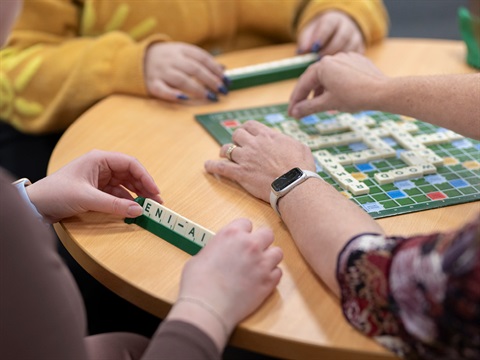 three people playing scrabble