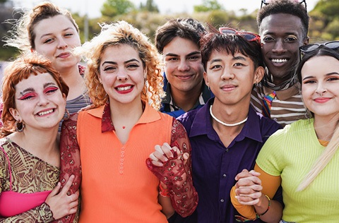 group of younger people smiling and holding hands