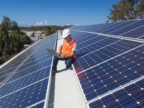 man on a roof with solar panels