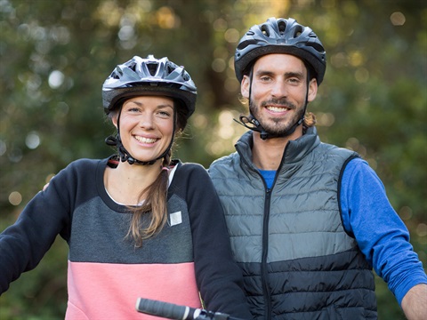 two people with bike helmets on smiling
