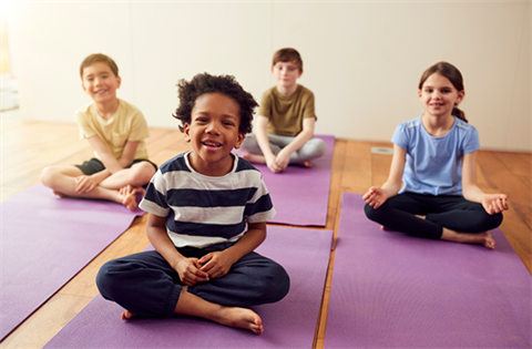 kids sitting cross-legged on yoga mats