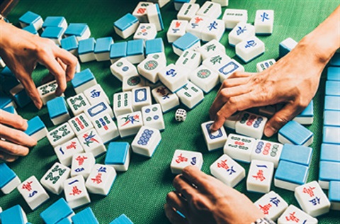 hands playing with mahjong tiles