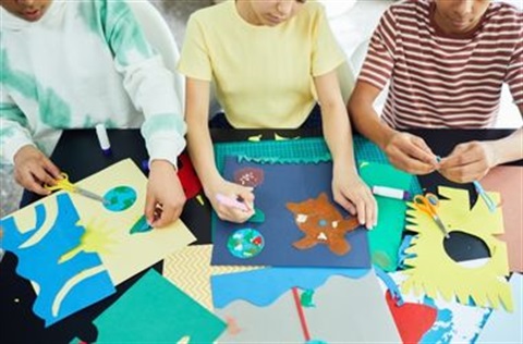Three children crafting with paper