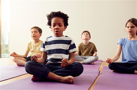 Kids sitting in yoga pose meditating