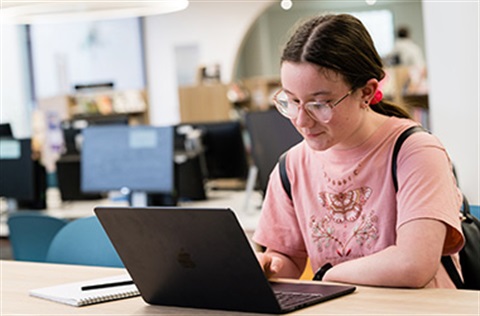 girl using a laptop in a library